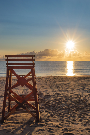 Lifeguard chair with early morning PEI beach sunrise.