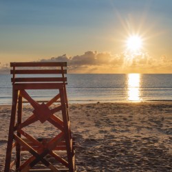 Lifeguard chair with early morning PEI beach sunrise.